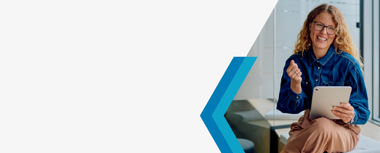 Businesswoman in glasses holding a tablet smiling because she found an affordable cloud ERP option: SAP Cloud ERP