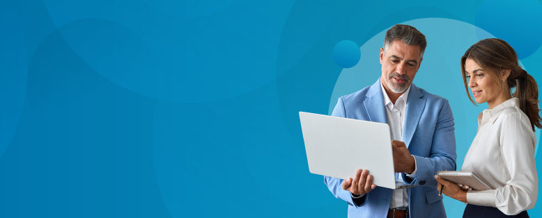 A business woman and man stands next to each other watching the Sage Intacct product tour for financial services on a laptop screen